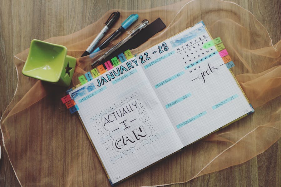 Open teacher planner book on a desk with pens and planning materials